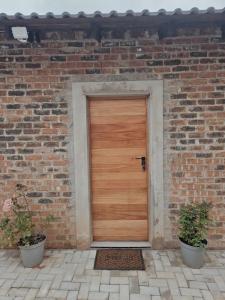 a wooden door in a brick building with two plants at Munnik Rest in Polokwane +2 photos