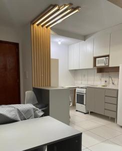 a kitchen with white cabinets and a counter top at Apartamento com piscina in Ponta Grossa