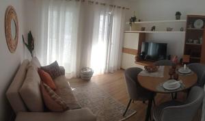 a living room with a couch and a table at Beach Blue Sesimbra in Sesimbra