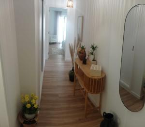 a hallway with a mirror and a table with plants at Beach Blue Sesimbra in Sesimbra