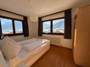 a bedroom with a bed and two windows at Haus Barbara in Waidring