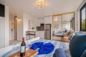 a living room with a wine bottle and two glasses on a table at Luxe Beachside Oasis Pool Parking by PH in San Juan