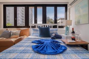 a bed with a blue blanket on top of it at Luxe Beachside Oasis Pool Parking by PH in San Juan