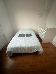 a small bedroom with a bed and a crib at Le Toit des Volcans - 8 couchages - Terrasse privée et Wifi in Clermont-Ferrand