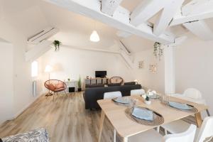 a living room with a table and a dining room at La porte de Moret in Moret-sur-Loing
