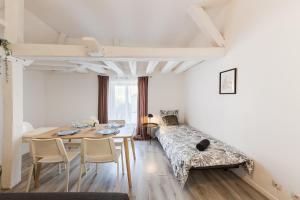 a room with a bed and a table and chairs at La porte de Moret in Moret-sur-Loing