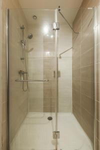 a shower with a glass door in a bathroom at La porte de Moret in Moret-sur-Loing +34 photos