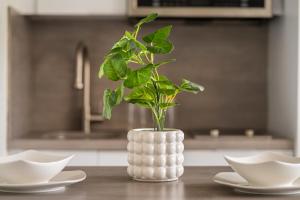 a white vase with a plant in it on a table at Luxe Beachside Oasis Pool Parking by PH in San Juan +26 photos