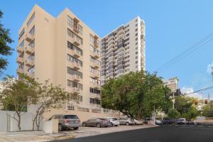 an apartment building with cars parked in a parking lot at Luxe Beachside Oasis Pool Parking by PH in San Juan