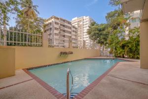 a swimming pool with buildings in the background at Luxe Beachside Oasis Pool Parking by PH in San Juan