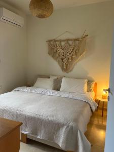 a bedroom with a white bed with a chandelier at Elysian Garden in Kalyves