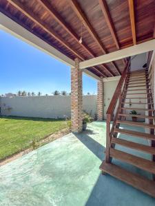 a stairway leading to a house with a wooden roof at Lumoa Beach Chalé Tutoia in Tutóia +8 photos