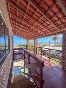 a porch of a house with a bench and the beach at Lumoa Beach Chalé Tutoia in Tutóia