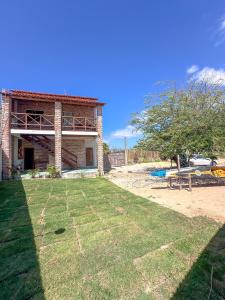 a house with a yard with a picnic table at Lumoa Beach Chalé Tutoia in Tutóia