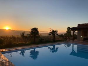 a swimming pool with the sunset in the background at Masia La Sort in Riba-roja d'Ebre
