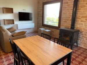 a living room with a table and a wood stove at Masia La Sort in Riba-roja d'Ebre
