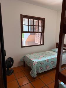 ein kleines Schlafzimmer mit einem Bett und einem Spiegel in der Unterkunft Prédio Jaque in Garopaba