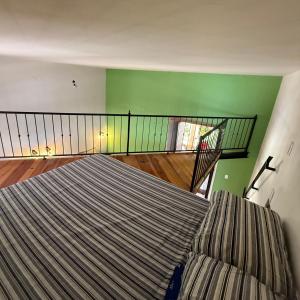 a room with a bed and a staircase with green walls at La Casa de Ticho in Mascota