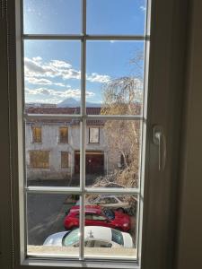 a window with a view of cars parked outside at Maisonnette Montferrandaise proche Tram - 6 couchages - tram - wifi in Clermont-Ferrand