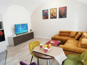 a living room with a table and a couch at Alma Apartment DOWNTOWN in Košice
