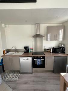 a kitchen with a sink and a stove top oven at Maisonnette Montferrandaise proche Tram - 6 couchages - tram - wifi in Clermont-Ferrand