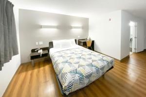 a bedroom with a bed and a wooden floor at The Reserve Inn in Salisbury +3 photos