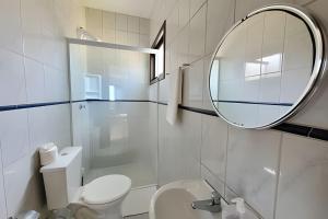 a bathroom with a white toilet and a mirror at Casa Morrinhos 01 in Garopaba +34 photos