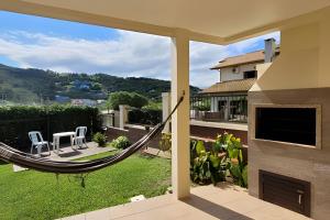 a hammock on the patio of a house at Casa Morrinhos 01 in Garopaba