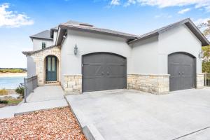 a white house with two garage doors at Lakeside Dreamhouse in Canyon Lake