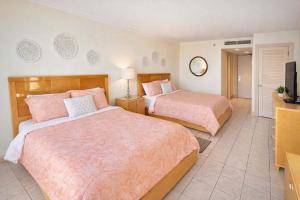 a bedroom with two beds and a television in it at Beachfront Resort with Heated Pool Saida Royale 9039 in South Padre Island