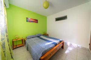 a bedroom with a bed and a green wall at KazAKaty in Trois-Rivières