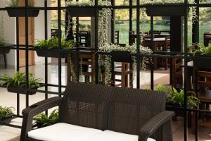 a chair in a room with potted plants at Hotel Nova El Peñol in El Peñol