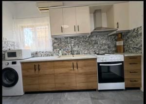 a kitchen with a stove and a sink and a dishwasher at Jimmy's Crib in Moúdhros