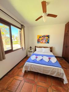 a bedroom with a bed and a ceiling fan at Residencial da Villa in Imbituba +69 photos