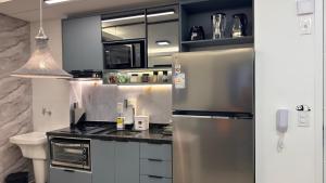 a kitchen with a stainless steel refrigerator and a sink at Ap Studio Premium luxuoso novíssimo! in Sorocaba