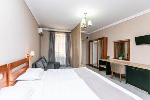 a bedroom with a large white bed and a desk at Residence Piata Sfatului in Braşov