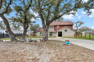 a house with two trees in front of a driveway at Lakeside Overlook in Canyon Lake