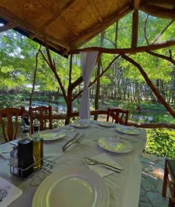 a table with plates and utensils on top at Hotel Restorant Natyra Diber Camping in Podgorcë +18 photos
