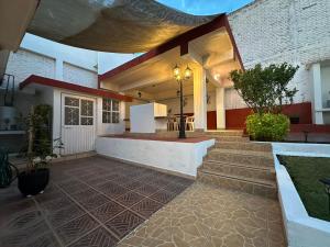 a home with a patio with a table and stairs at Casa Brasa, Sol & Jardín in Guanajuato
