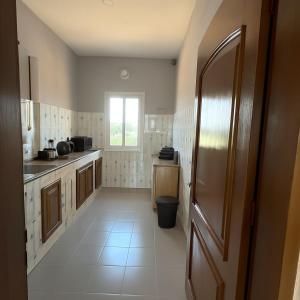 a kitchen with a door open to a kitchen with white tiles at Les Résidences CICA in Ouidah
