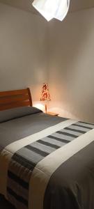 a bedroom with a bed with a lamp next to it at Casa Brasa, Sol & Jardín in Guanajuato