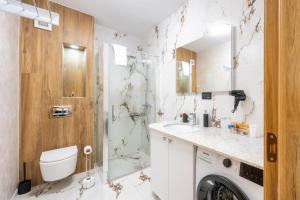 a bathroom with a shower and a toilet and a sink at NXN Airportstay in Cluj-Napoca +26 photos