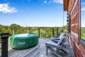a deck with two chairs and a bath tub on it at Ozuye Lodge in Fischer