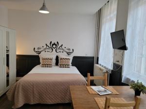 a bedroom with a bed and a table at Studio 1 du Temple Hyper Centre in Cambrai