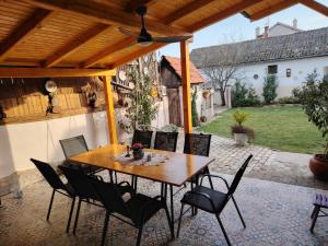 a wooden table and chairs on a patio at Apartman Katarina Bački Monoštor in Bački Monoštor