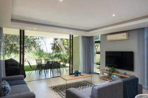 a living room with a couch and a tv and a table at 23 The Sanctuary Zimbali in Ballito