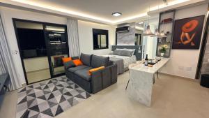 a living room with a couch and a bed at Ap Studio Premium luxuoso novíssimo! in Sorocaba