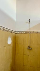 a bathroom with a shower with a yellow wall at Kasbah Restaurant Citoyenne in Agoudal +146 photos
