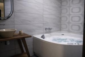 a bathroom with a bath tub and a sink at Hôtel De La Promenade in Chevigney +32 photos
