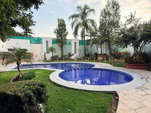 a swimming pool in the middle of a yard at Áurea Hotel and Suites in Guadalajara
